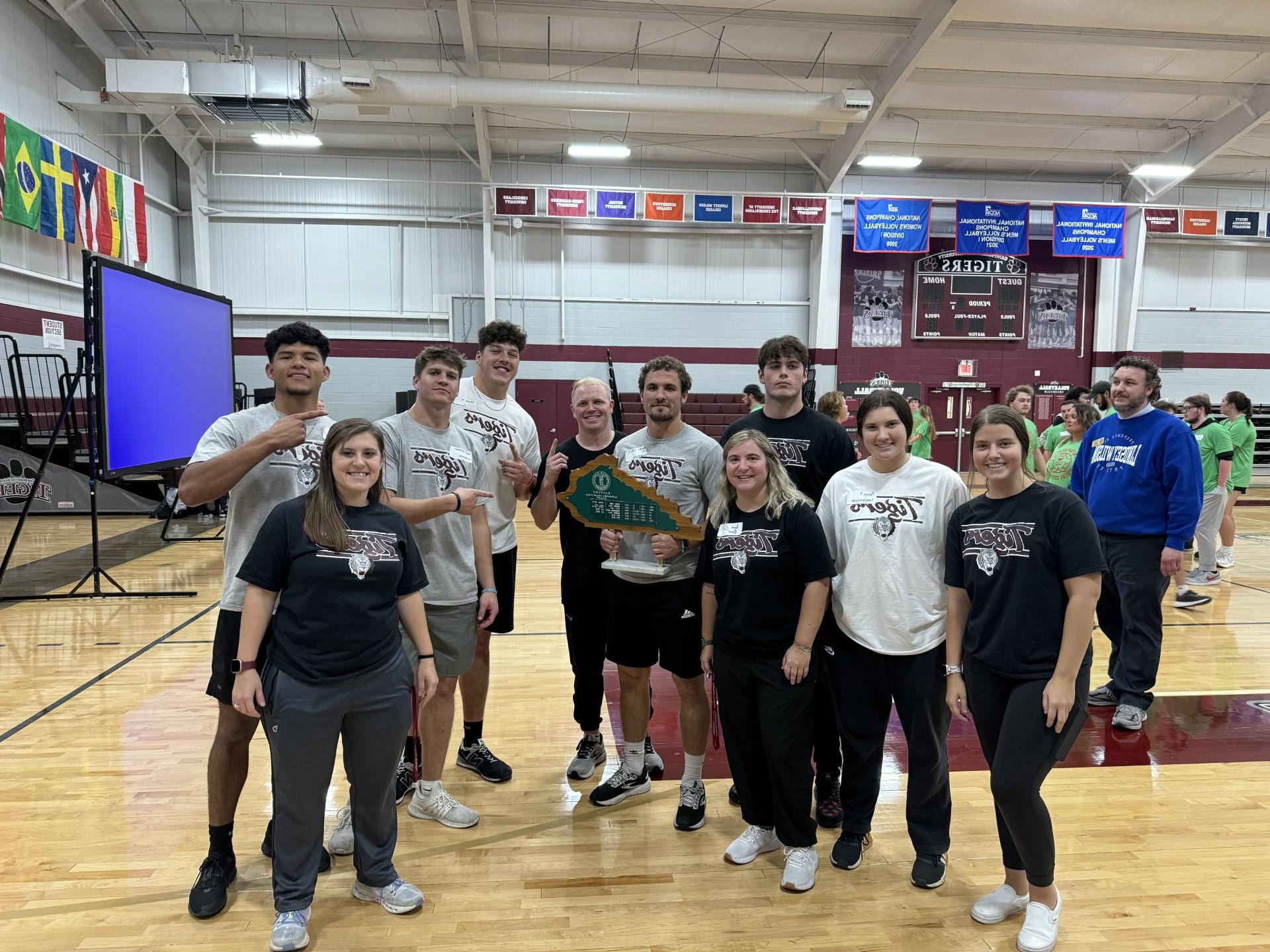 Faculty and students holding a trophy